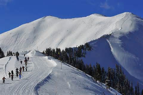Skiers hiking up Highland Bowl in Aspen